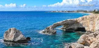 აია-ნაპა: კვიპროსის მზისფერი სამოთხე და დაუვიწყარი თავგადასავალი Natural stone bridge and sea caves at Cape Greco near Ayia Napa, Cyprus, with turquoise Mediterranean water.